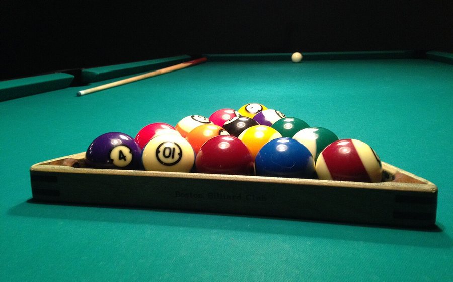 Racked billiard balls on green tournament cloth
